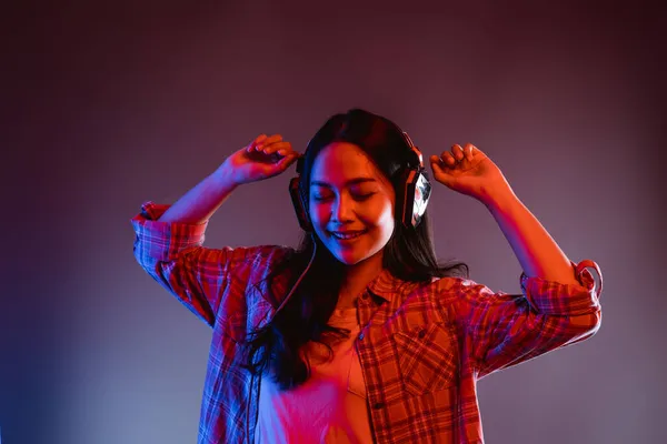 Жінка закриває очі під час прослуховування музики в навушниках, танцюючих — стокове фото