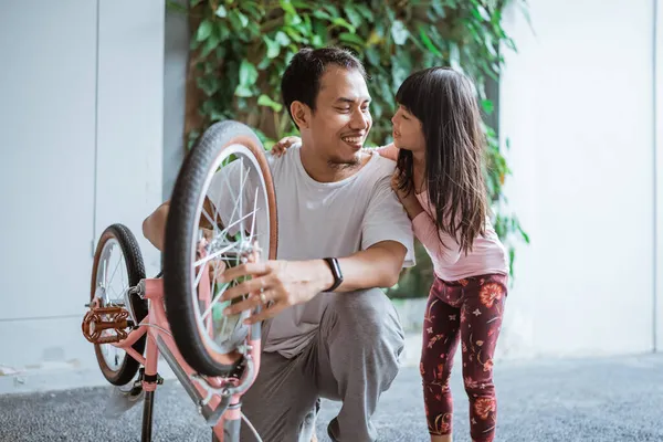 Otec instalovat kola při chatování se svou dcerou — Stock fotografie