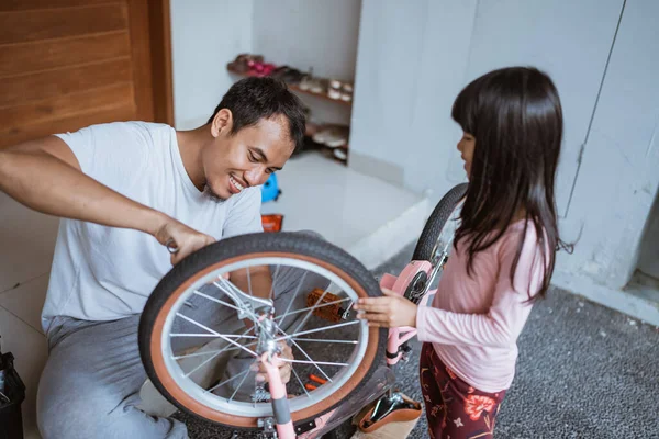 亚洲父亲用扳手和女儿一起修理自行车 — 图库照片