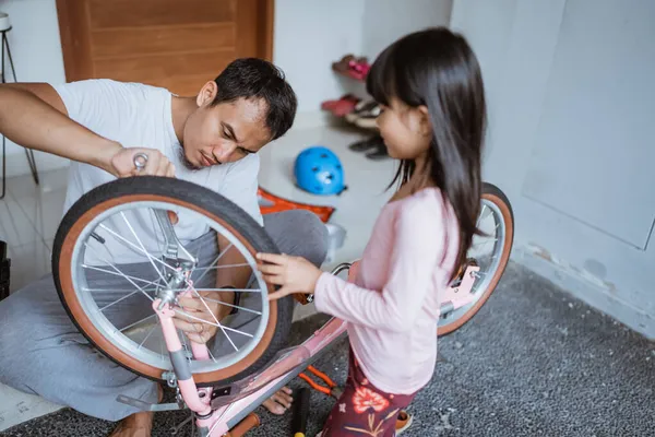 Asiatische Vater verwenden einen Schraubenschlüssel, um Radschrauben festzuziehen — Stockfoto
