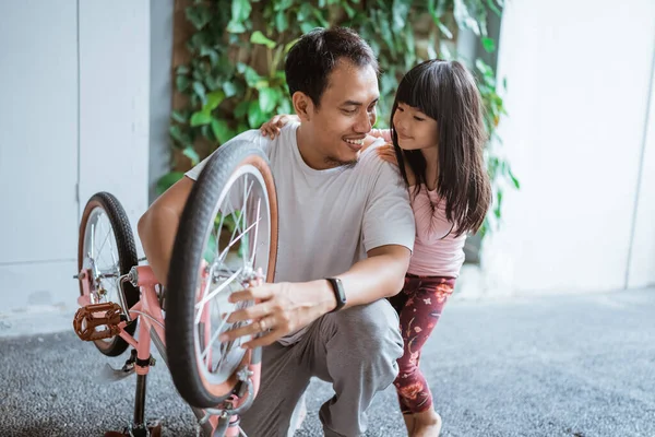 父と娘が子供の自転車を修理する場所 — ストック写真