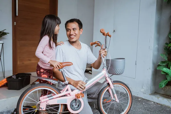 Glücklicher Vater mit Fahrrad und Blick auf seine Tochter — Stockfoto