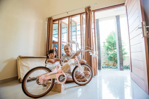 Tochter packt neues Mini-Fahrrad mit Papa im Wohnzimmer aus — Stockfoto