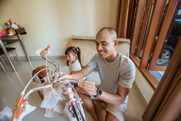 Asiático papá poner en nuevo mini bicicleta manillar con hija — Foto de Stock