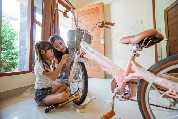 Hija y madre se divierten instalando su nueva cesta de bicicletas —  Fotos de Stock