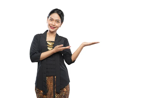 Beautiful woman wearing Kebaya with hand gesture presenting something beside her — Stock Photo, Image