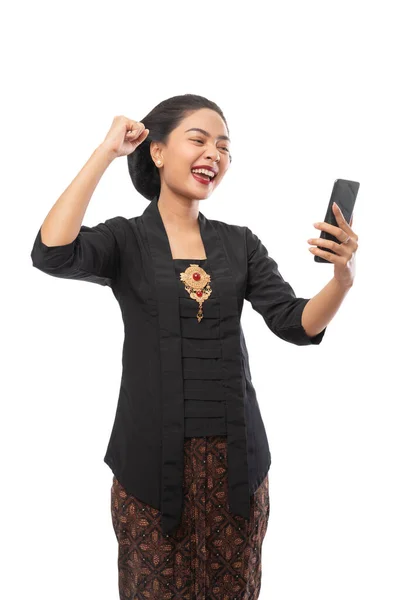 Donna con vestiti kebaya felice guardando il telefono — Foto Stock