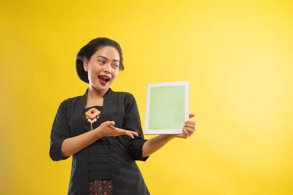 Glückliche asiatische Frau mit Kebaya zeigt Tablet-Bildschirm — Stockfoto