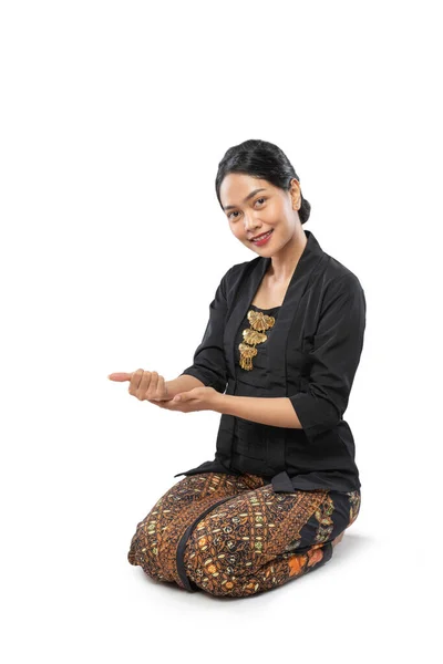 Wanita cantik mengenakan pakaian tradisional Jawa menyajikan mengundang — Stok Foto