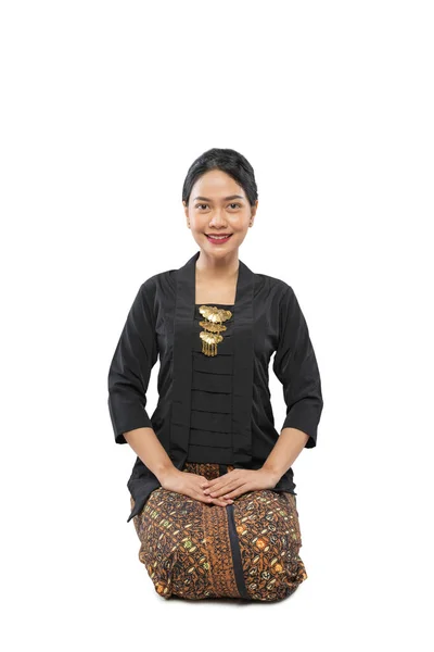Kniel op de vloer vrouw draagt traditionele Javaanse jurk Kebaya — Stockfoto