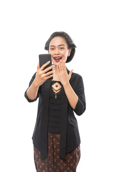 Kvinna med kebaya kläder glad tittar på telefonen — Stockfoto