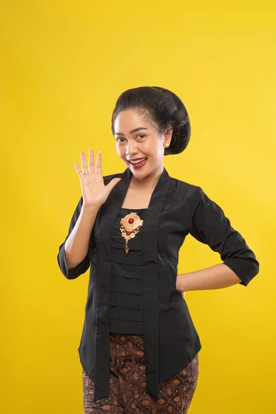 Excited woman with kebaya waving hands and one hand on waist — Stock Photo, Image