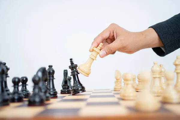 Mano che tiene il re per abbattere il re mentre gioca a scacchi — Foto Stock