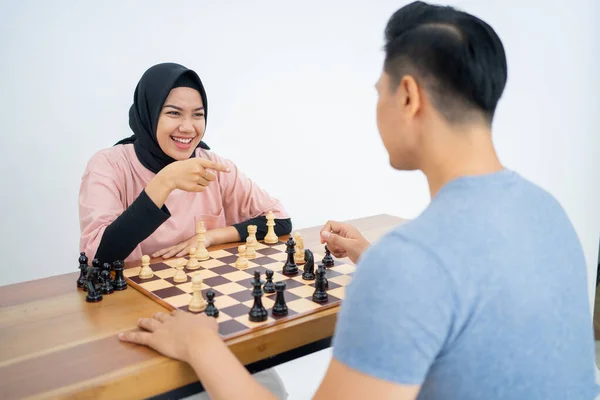 Χαμογελώντας μουσουλμάνα γυναίκα με το χέρι δείχνει ενώ παίζει σκάκι — Φωτογραφία Αρχείου