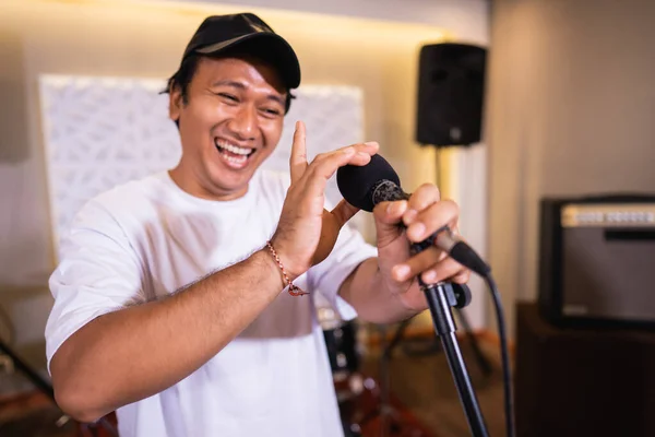 Um vocalista ri enquanto prepara e verifica o microfone antes de usar — Fotografia de Stock