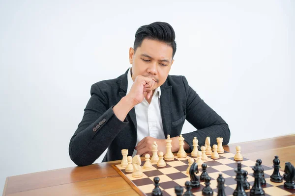 L'uomo pensa prima di fare un passo quando gioca a scacchi su sfondo isolato — Foto Stock
