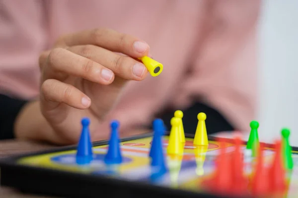 En person hand när du spelar ludo på bordet — Stockfoto