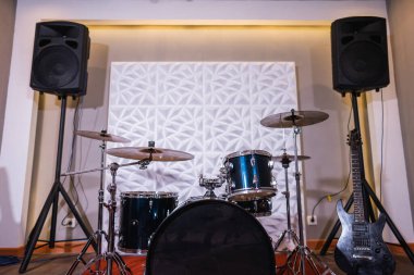 Davul seti, elektro gitarı ve hoparlörü olan zarif bir oda.