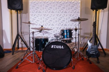 Davul seti ve elektro gitarı olan bir oda.
