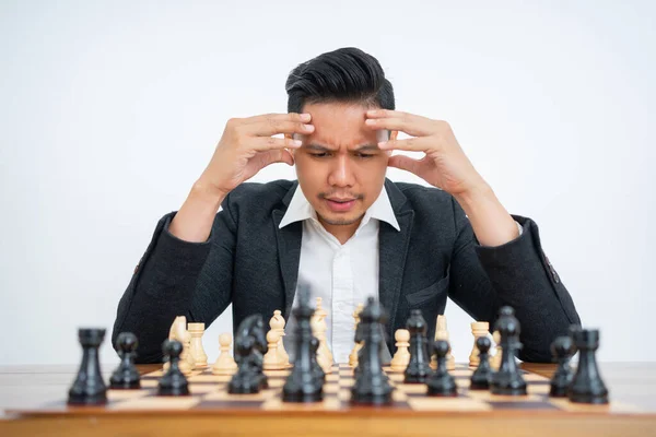 Hombre con un gesto de pensamiento en un tablero de ajedrez —  Fotos de Stock