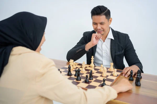 Uomo in giacca e cravatta guardando i pezzi degli scacchi mentre gioca a scacchi — Foto Stock