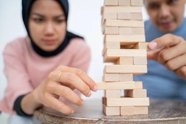 Sowohl weibliche als auch männliche Hände versuchen, Blöcke aufzuheben — Stockfoto