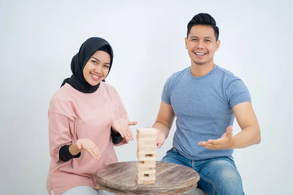 Frau und Mann mit Handbewegung präsentieren spielenden Holzblock — Stockfoto