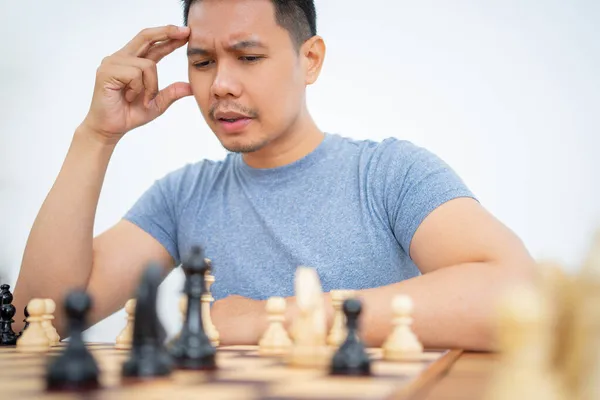 Giovane uomo con le mani sulla testa mentre gioca a scacchi — Foto Stock