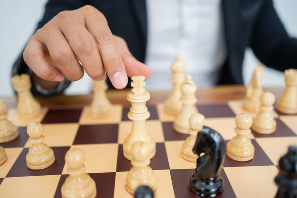 Hand holding king to step while playing chess