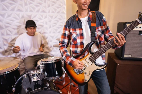 Κιθαρίστας παίζει κιθάρα ενώ παίζει με ντράμερ στο παρασκήνιο — Φωτογραφία Αρχείου