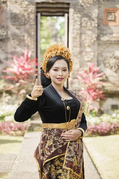 Mooie vrouw draagt traditionele Balinese kleding staande met een goed gebaar — Stockfoto