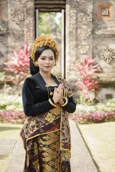 Mujer vistiendo ropa tradicional balinesa de pie gesto de bienvenida —  Fotos de Stock