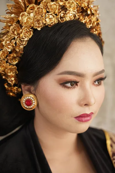 Женщина в ювелирных украшениях, короне Пайас и балийской кебайе в помещении — стоковое фото