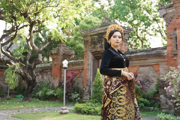 Ασιάτισσα που φοράει κεμπάγια από το Μπαλί και υφαντό ύφασμα όρθια — Φωτογραφία Αρχείου