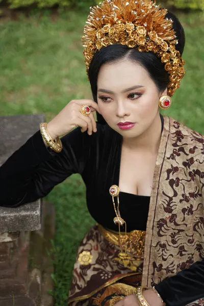 Piękna kobieta w balijskiej kebaya i tkane tkaniny siedzi — Zdjęcie stockowe