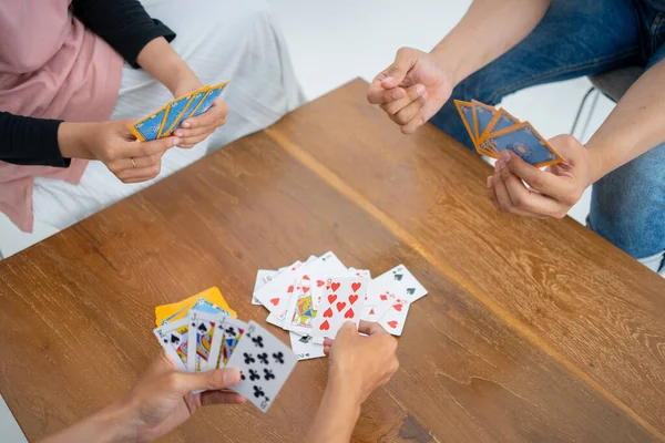 Handen die kaarten uitgeven aan tafel terwijl ze samen kaarten spelen — Stockfoto