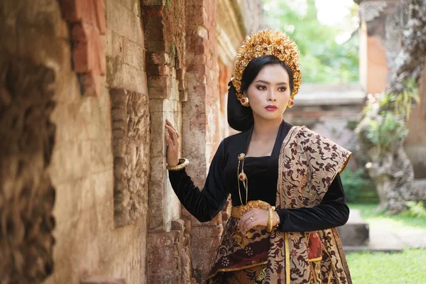 Ázsiai nő visel balinéz kebaya mellett egy dombormű fal — Stock Fotó