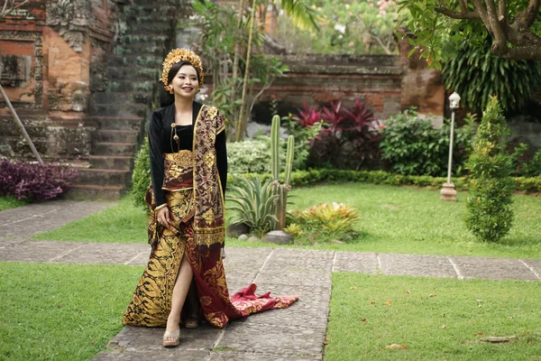 Smiling woman wearing Balinese kebaya walking on the path — Stock Photo, Image