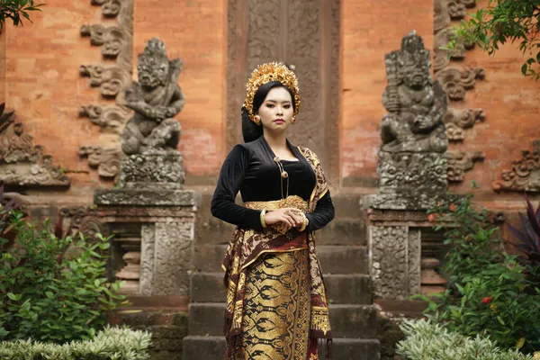 इंडोनेशियाई महिला बाली केबाया और मंदिर के खिलाफ बुना हुआ कपड़ा पहनती है — स्टॉक फ़ोटो, इमेज