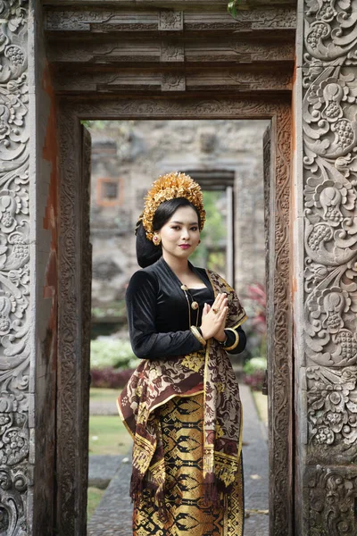 Balinese woman wearing traditional dress with welcome gesture — Stock Photo, Image