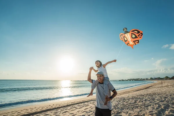 Feliz pai e filha voando pipa juntos na praia — Fotografia de Stock