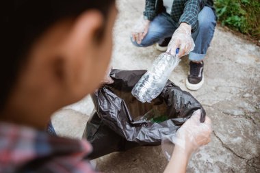 Genç gönüllüler çöpleri toplayarak çevreyi temiz tutuyorlar.