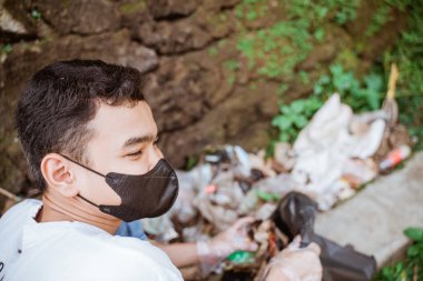 Genç gönüllüler çöpleri toplayarak çevreyi temiz tutuyorlar.