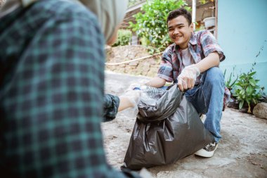 Genç gönüllüler çöpleri toplayarak çevreyi temiz tutuyorlar.