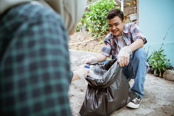 Jonge vrijwilligers houden het milieu schoon door vuilnis op te ruimen — Stockfoto