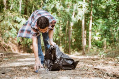 Genç gönüllüler çöpleri toplayarak çevreyi temiz tutuyorlar.