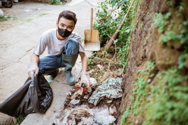 Genç gönüllüler çöpleri toplayarak çevreyi temiz tutuyorlar.