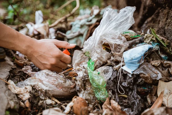 El plastik atıkları topluyor ve çöp torbasına koyuyor. — Stok fotoğraf