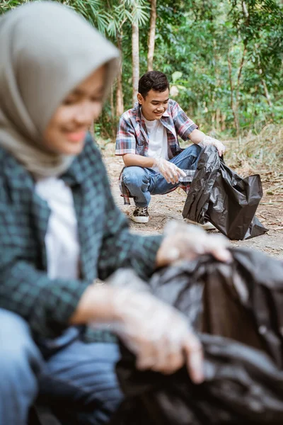 Двоє щасливих добровольців-підлітків, які збирають сміття — стокове фото