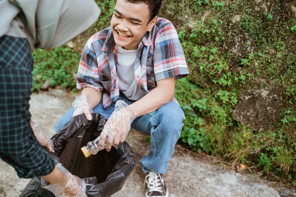 Two happy teenage volunteers picking up trash — Stock Photo, Image